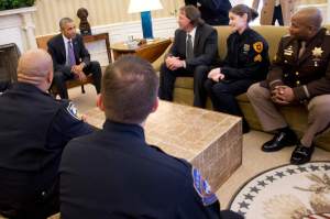 (Jacquelyn Martin | The Associated Press) President Barack Obama talks with Officer Allan Gerking of the Puyallup, Wash., Tribal Police Departmen, center, Sgt. Charli Goodman of the Salt Lake City Police Department and Cpl. Dorrell Savoy of the Charles County, Md., Sheriff’s Office, as he meets Tuesday with law enforcement officials from across the country in the Oval Office of the White House. In the foreground are Officer Erik Oliver of the Richmond, Calif., Police Department, left, and Officer Matthew Thomas of the Indianapolis Metropolitan Police Department.